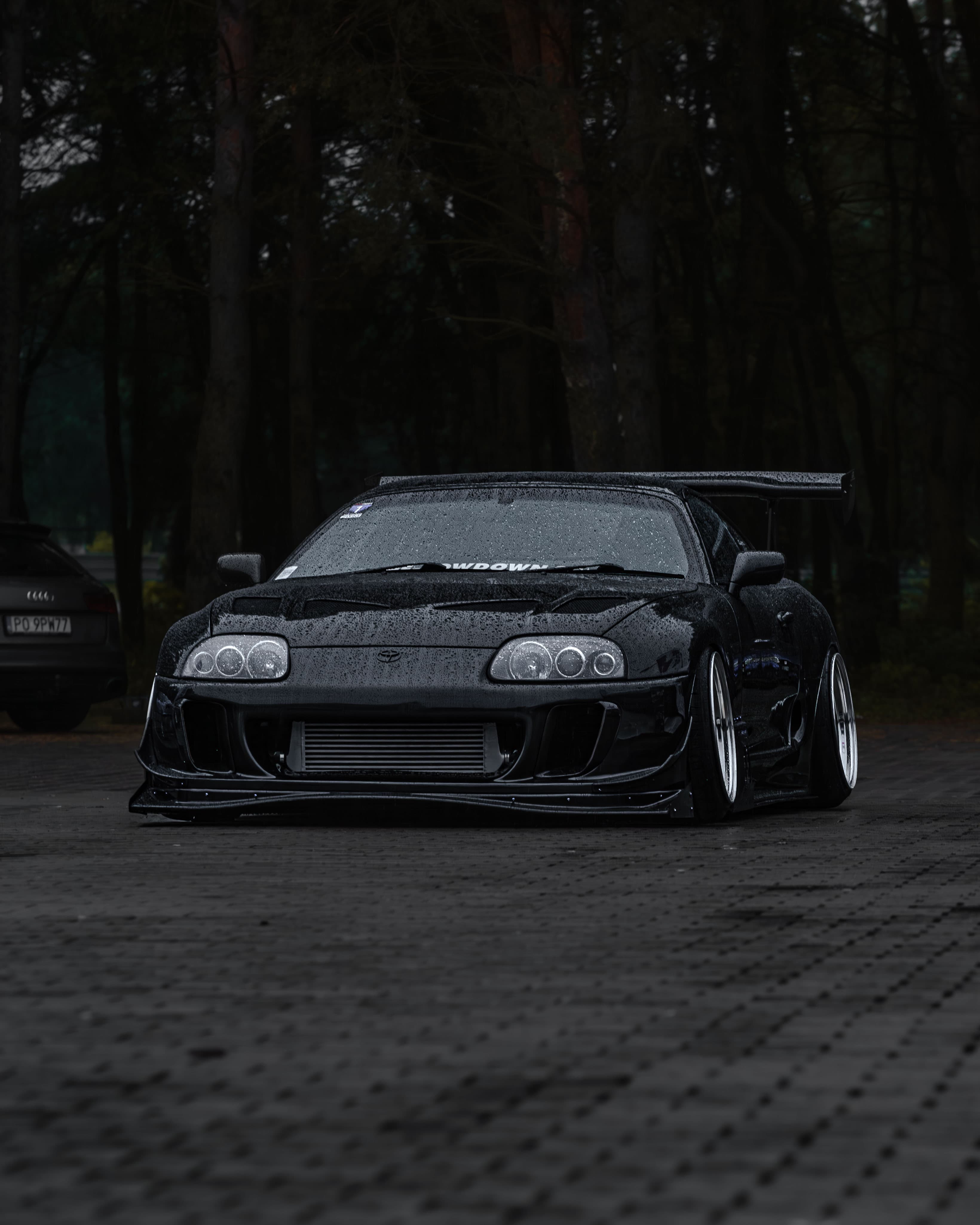 Toyota Supra na tle deszczowego lasu